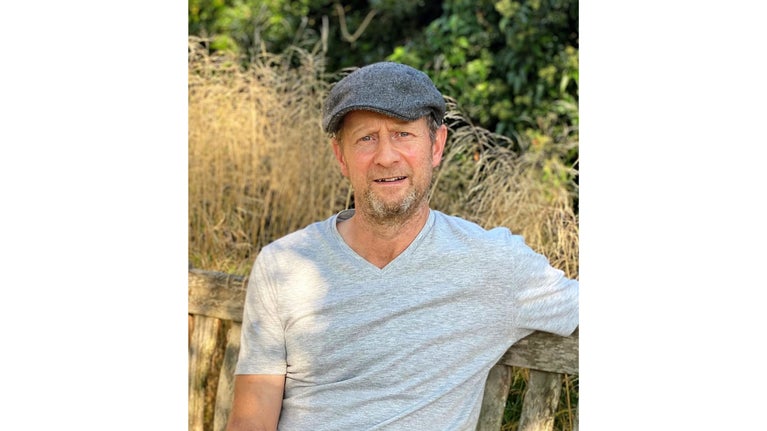 Portrait of a man with a grey hat and a white t-shirt